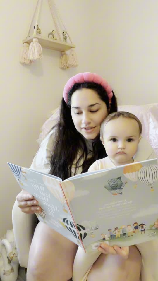 Mother reading a picture book with her child at home